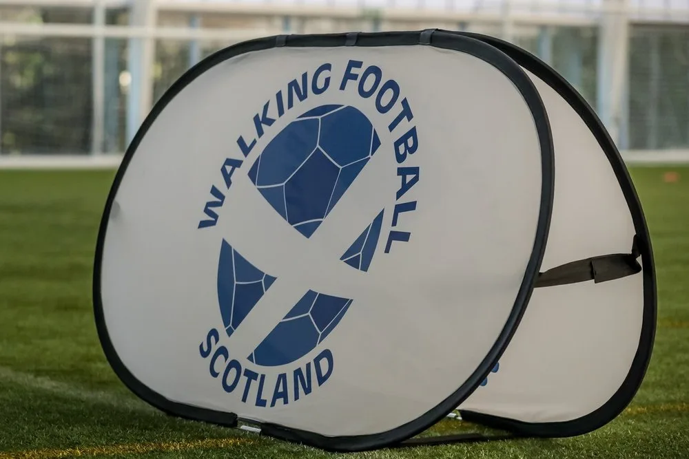 Identidade visual da Walking Football Scotland em campo esportivo.