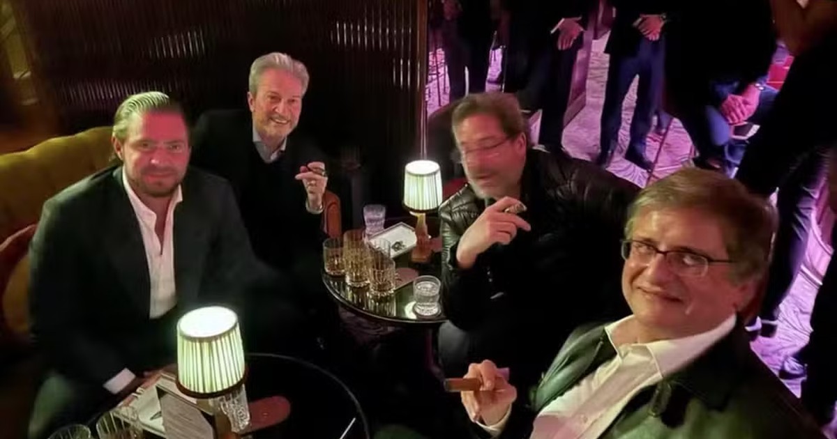 Fotografia de encontro em Londres com Daniel Vorcaro à esquerda e Paulo Gonet à direita, sentados com outras pessoas